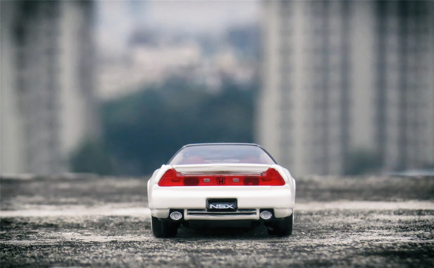 同じ白いミニカーを後方から見た別カット。赤いテールランプとNSXのプレートを確認できます。